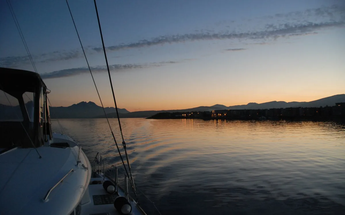 A sailing catamaran in a fjord near Tromso at sunset