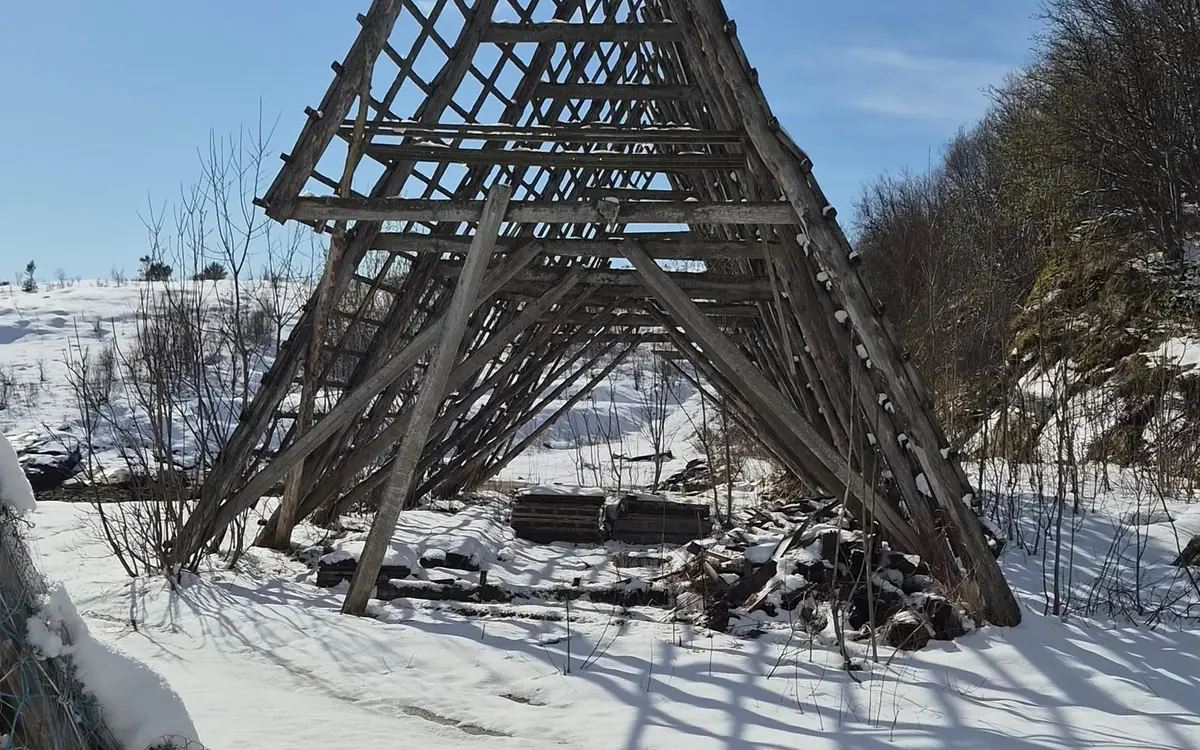 Wooden fish-drying racks on the shore of a fjord near Tromso